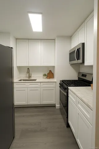 a kitchen with stainless steel appliances white cabinets and a sink