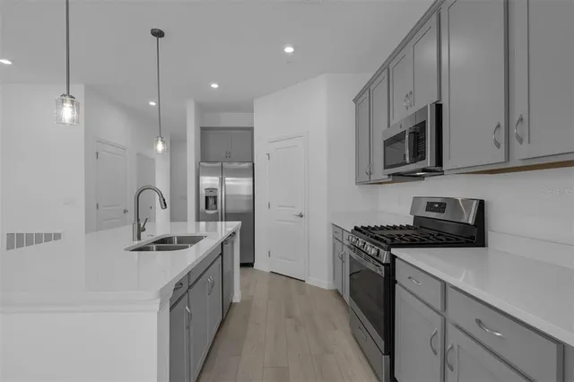 a kitchen with stainless steel appliances granite countertop a sink stove and refrigerator