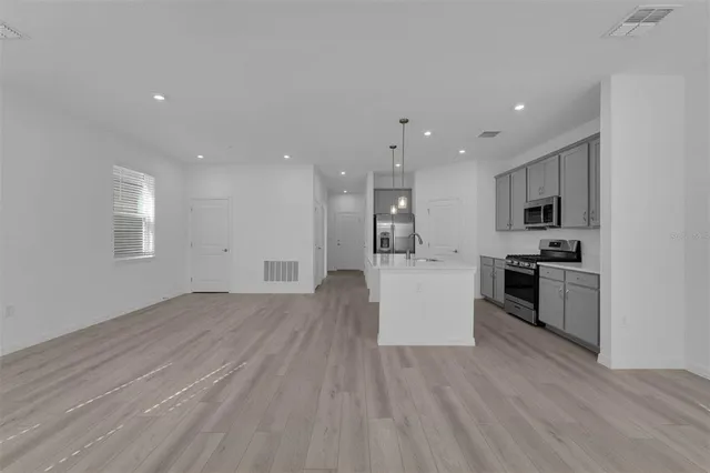 a view of kitchen with cabinets stainless steel appliances and window