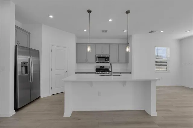 a large kitchen with stainless steel appliances kitchen island a large counter top and stove