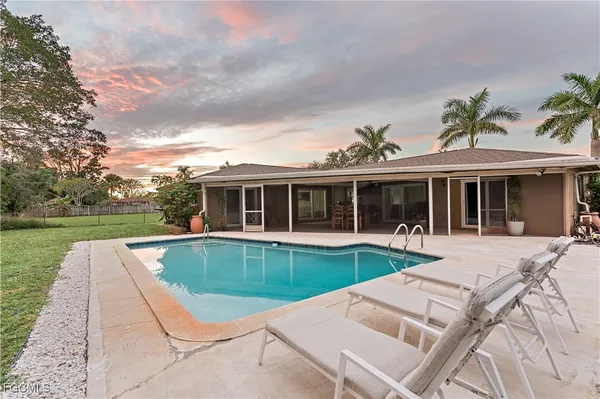 a view of a house with swimming pool and a yard
