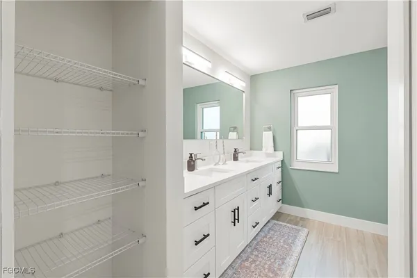 a bathroom with a double vanity sink a toilet and a window