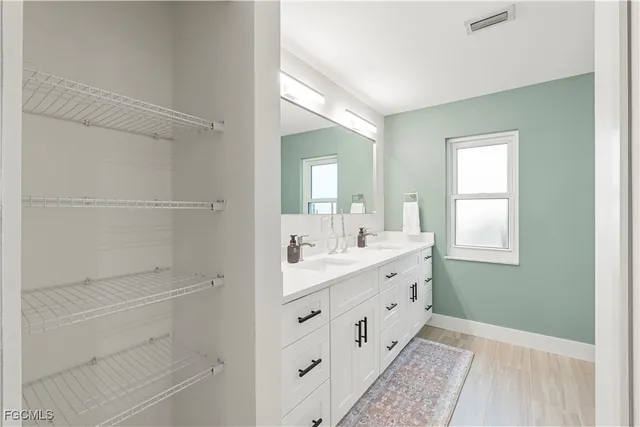 a bathroom with a double vanity sink a toilet and a window