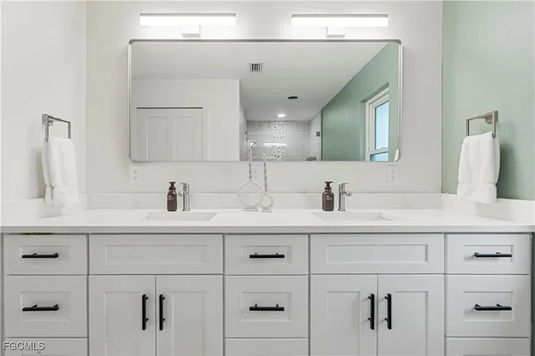 a bathroom with a sink vanity and mirror