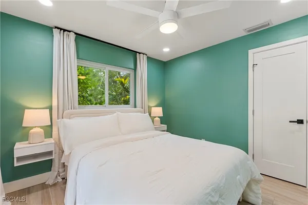 a bedroom with a bed and a large window