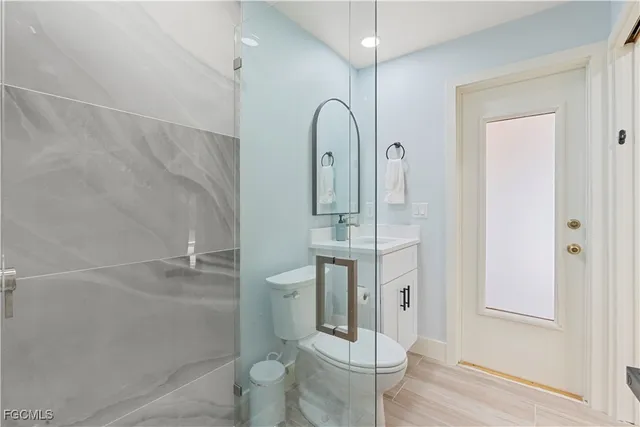 a bathroom with a toilet a sink and mirror