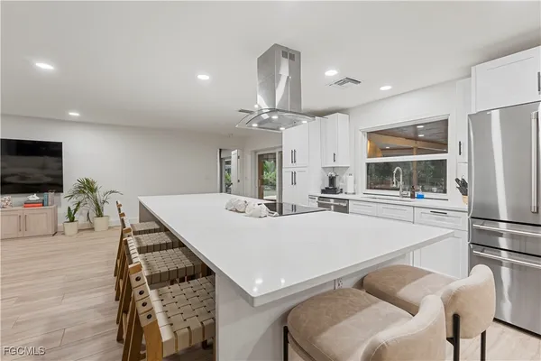 a large kitchen with kitchen island a stove a table and chairs