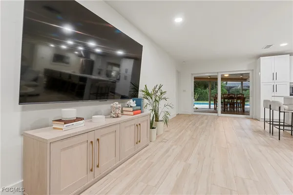 a room with stainless steel appliances kitchen island granite countertop a sink a stove and a wooden floors