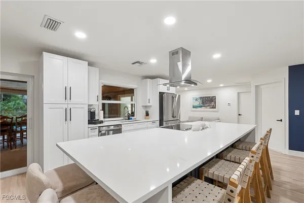 a large kitchen with kitchen island a sink table and chairs