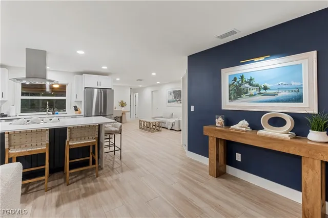 a living room with furniture a dining table and kitchen view with wooden floor