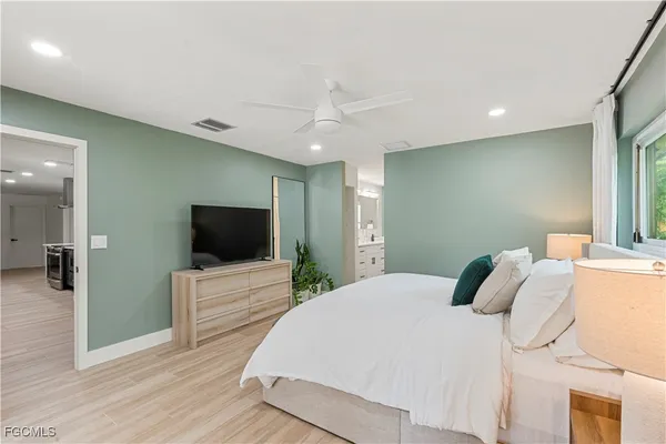 a bedroom with a bed and a flat screen tv