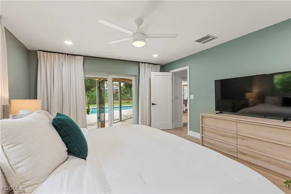 a bedroom with a large bed and a flat screen tv