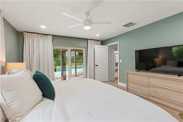 a bedroom with a large bed and a flat screen tv