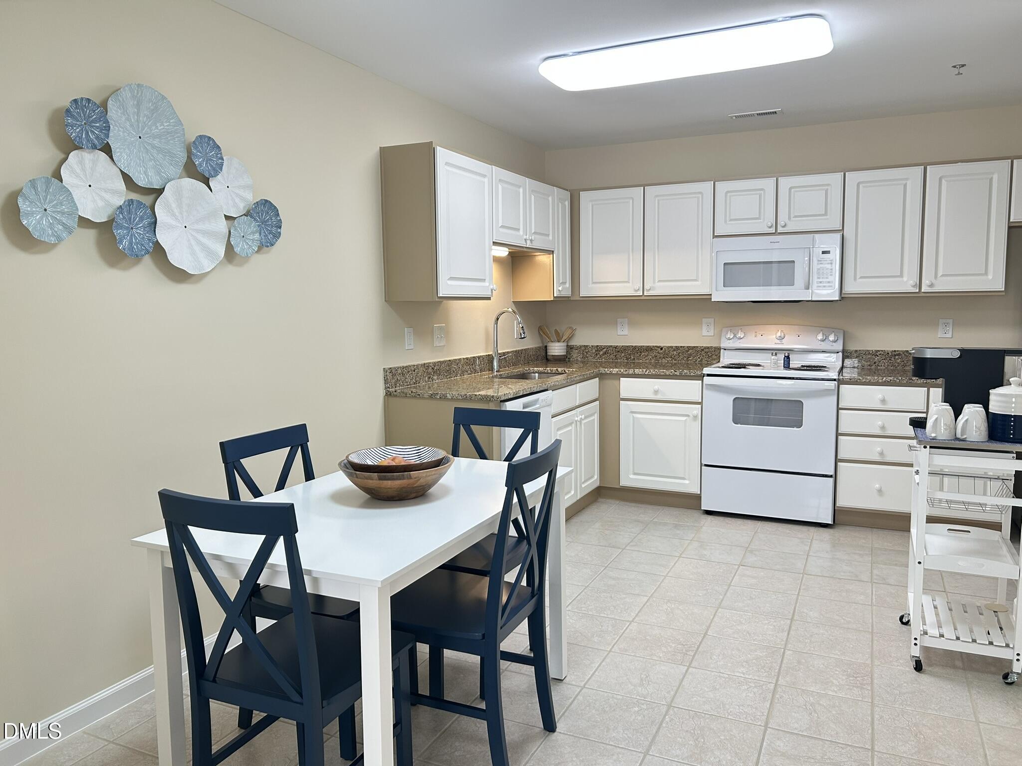 2510 Friedland Place, Unit 102 Raleigh, NC 27617 - Photo 7 of 42 a kitchen with a stove a table and chairs in it