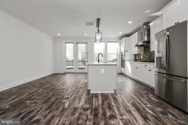 a kitchen with a refrigerator a sink and cabinets