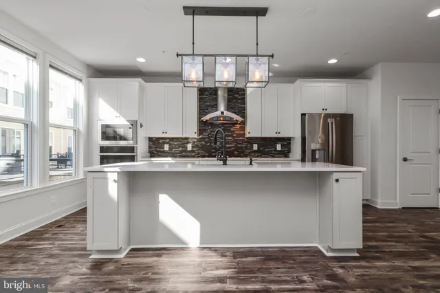 a kitchen with stainless steel appliances granite countertop a refrigerator a sink and a stove