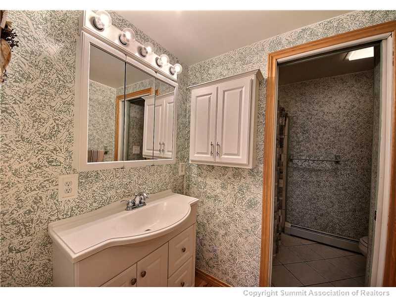 63 Idlewild Drive Summit Cove, CO 80435 - Photo 17 of 25 a bathroom with a sink a mirror and a shower