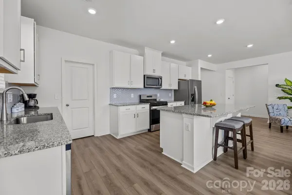 a large kitchen with stainless steel appliances granite countertop a lot of counter space and a sink