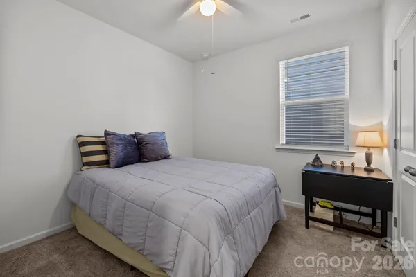a large bed sitting in a bedroom next to a window