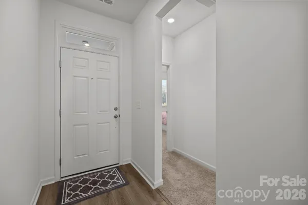 a utility room with stainless steel appliances lots of clutter and fridge