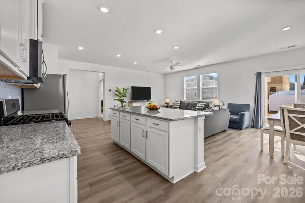 a kitchen with granite countertop white cabinets and stainless steel appliances