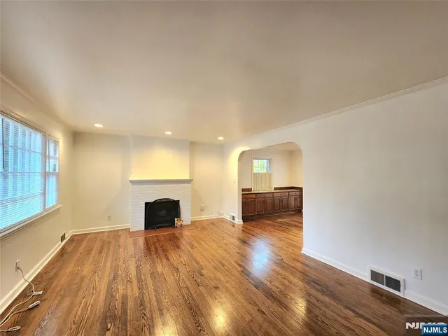 a view of a room with wooden floor and a fireplace
