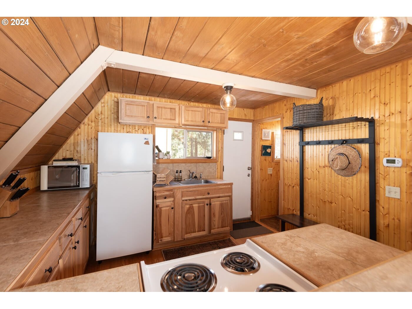 16942 Downey Road Bend, OR 97707 - Photo 8 of 22 a kitchen with a refrigerator a stove and a wooden cabinets