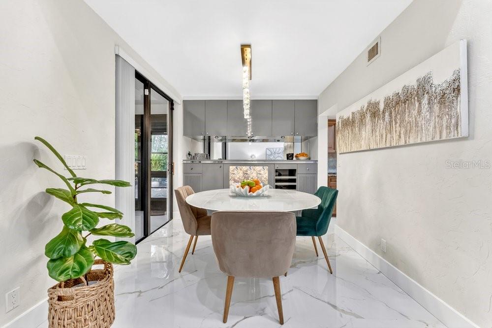 7838 La Mirada Drive Boca Raton, FL 33433 - Photo 16 of 43 a white table sitting in a kitchen with furniture and a chandelier