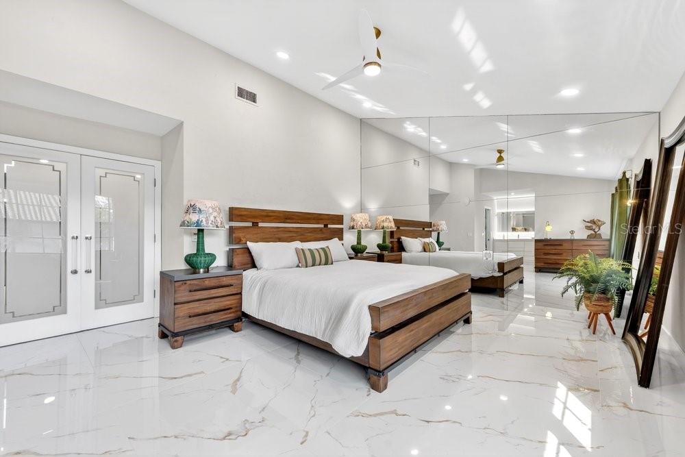 7838 La Mirada Drive Boca Raton, FL 33433 - Photo 24 of 43 a spacious bedroom with a bed and a chandelier