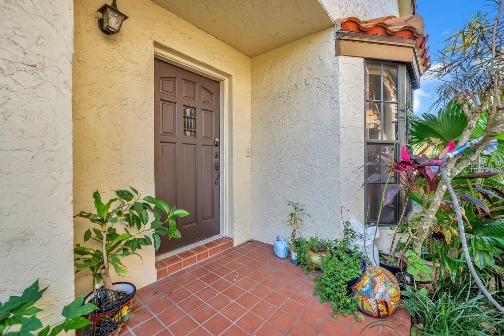 7838 La Mirada Drive Boca Raton, FL 33433 - Photo 5 of 43 a flower garden with a chair