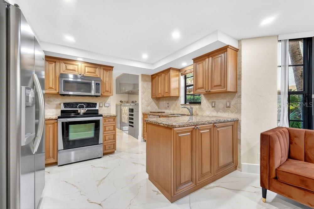 7838 La Mirada Drive Boca Raton, FL 33433 - Photo 10 of 43 a kitchen with stainless steel appliances granite countertop a stove a sink and a refrigerator
