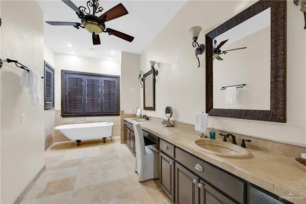 a bathroom with a tub double vanity sink and mirror