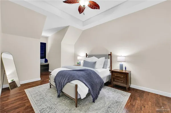 a spacious bedroom with a bed and wooden floor