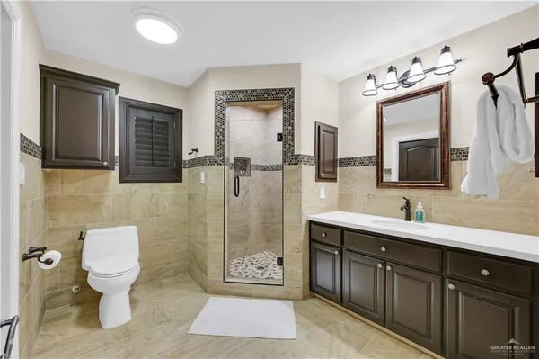a bathroom with a sink toilet a mirror and shower