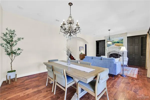 a living room with furniture a fireplace and a chandelier
