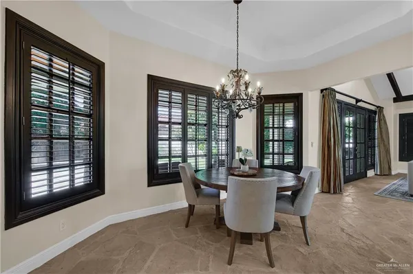 a dining room with furniture a chandelier and window