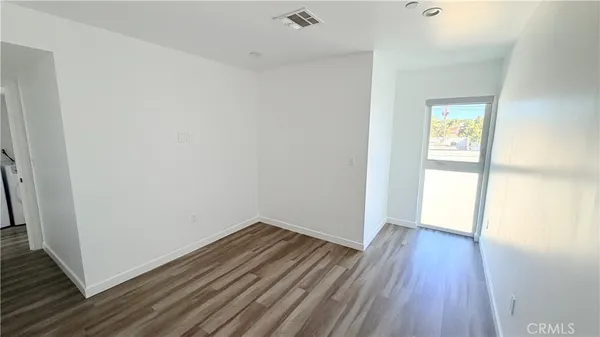 a view of a room with wooden floor and a window