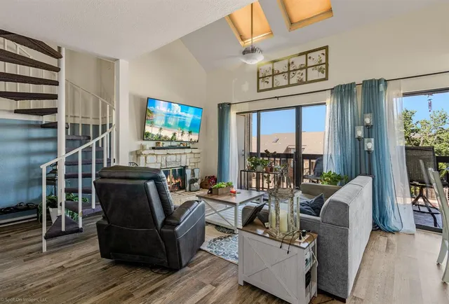 a view of a livingroom with furniture hardwood floor and windows