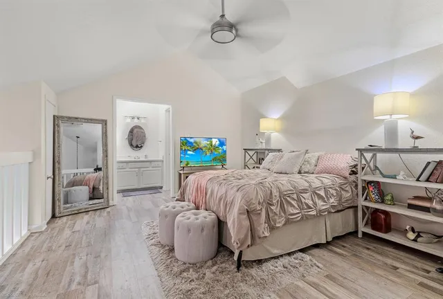 a spacious bedroom with a bed and a mirror