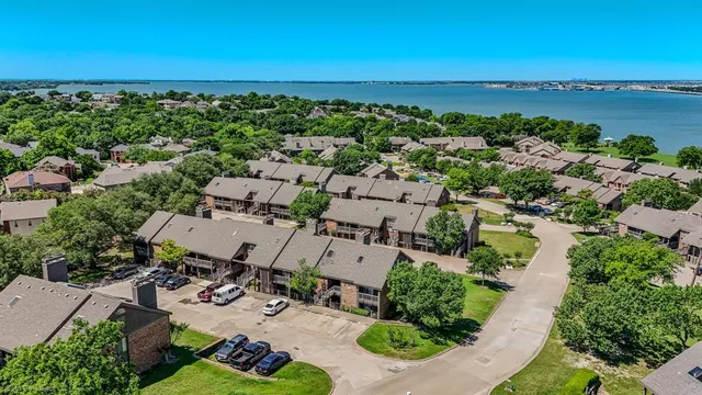 an aerial view of a city with lots of residential buildings ocean and mountain view in back