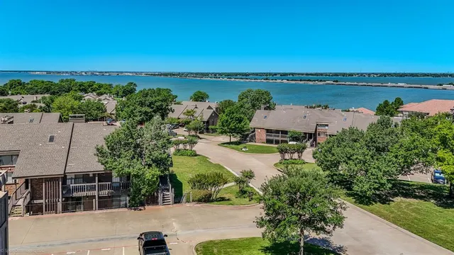 an aerial view of a house with green landscape and water view