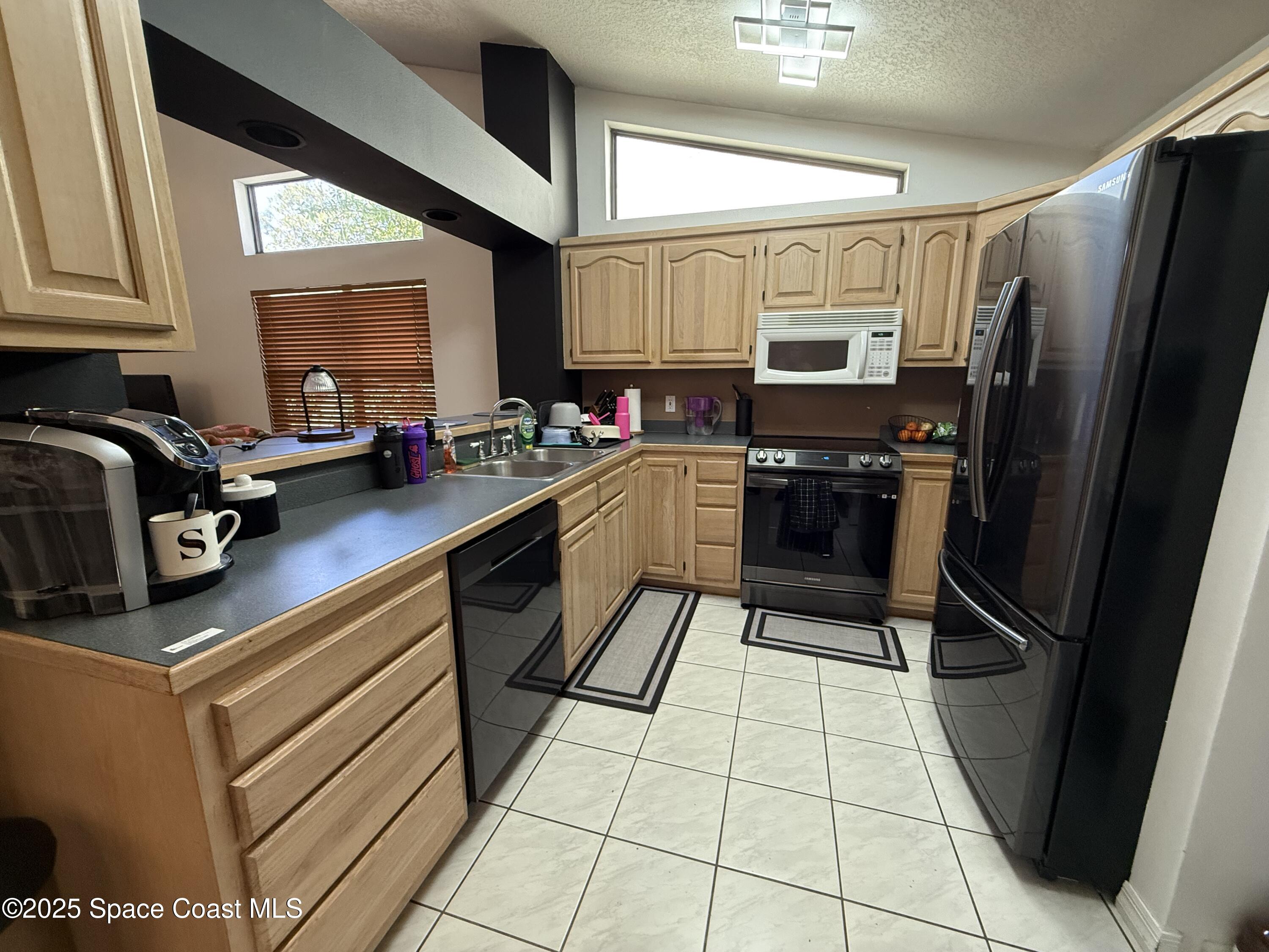 3960 Raney Road Titusville, FL 32780 - Photo 12 of 33 a kitchen with a sink a stove and refrigerator