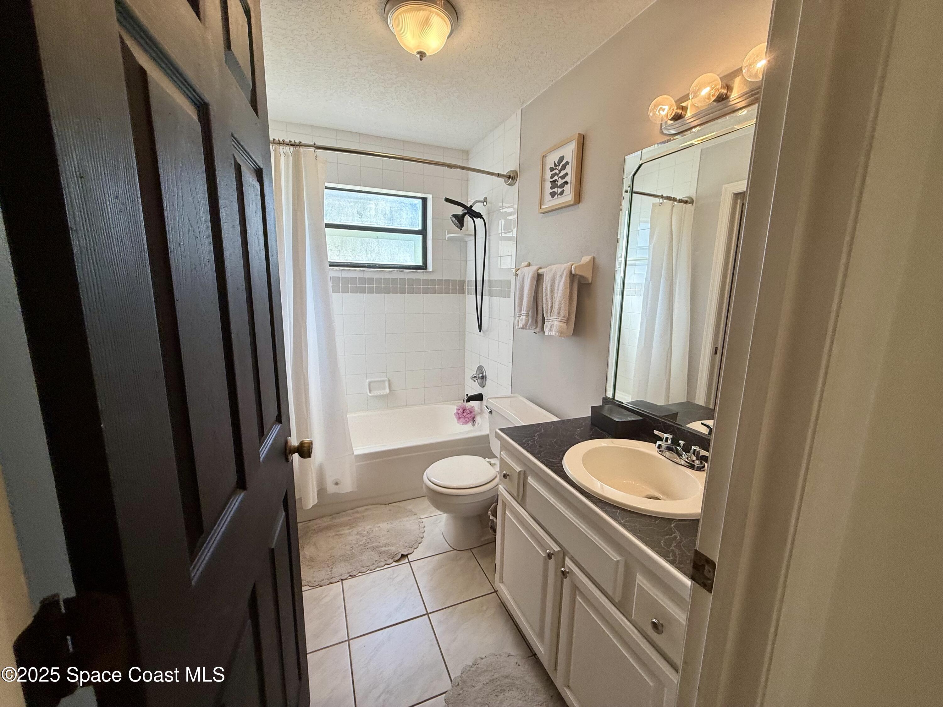 3960 Raney Road Titusville, FL 32780 - Photo 17 of 33 a bathroom with a sink a toilet a mirror and shower