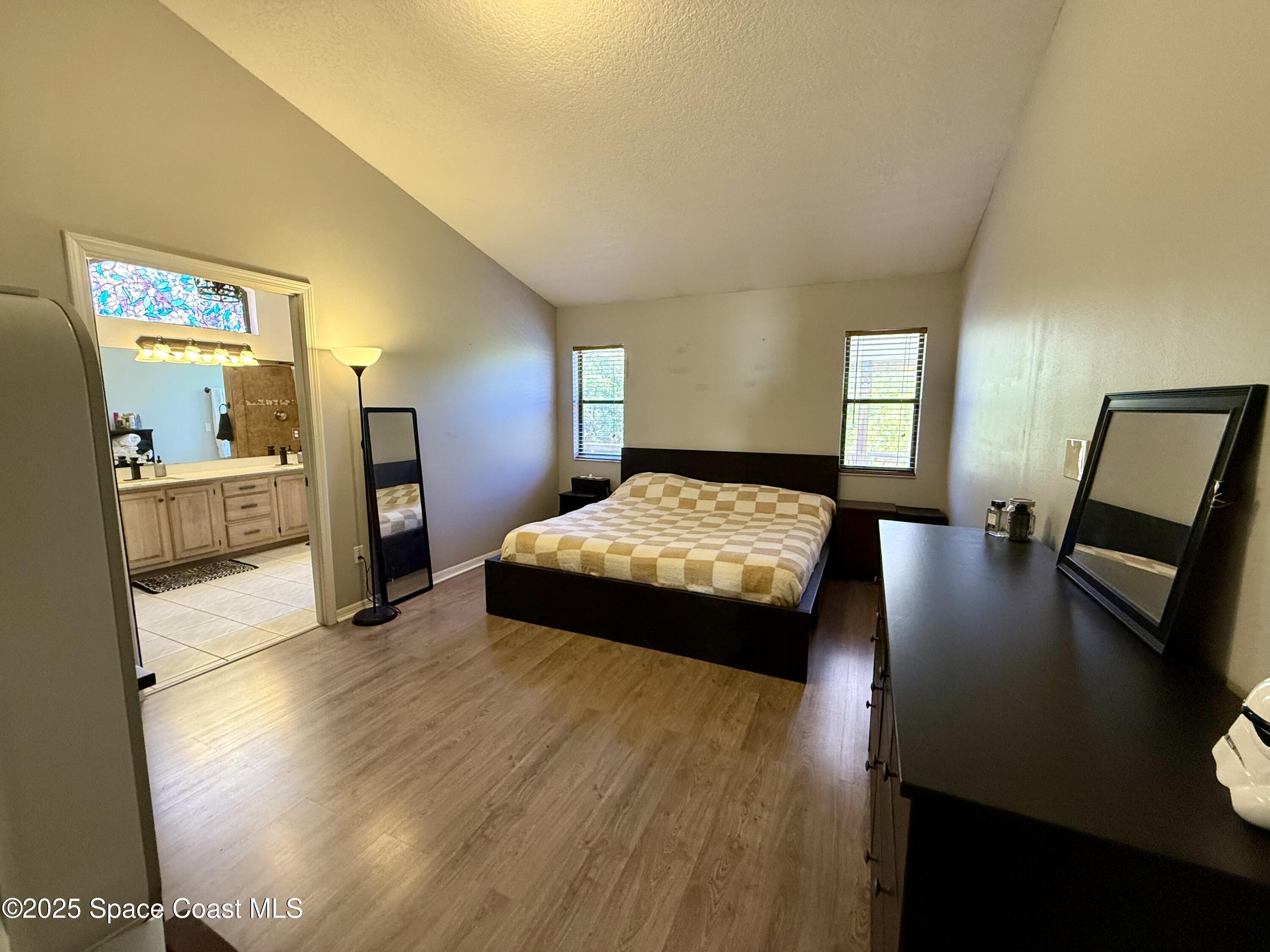 3960 Raney Road Titusville, FL 32780 - Photo 18 of 33 a bedroom with a bed and wooden floor