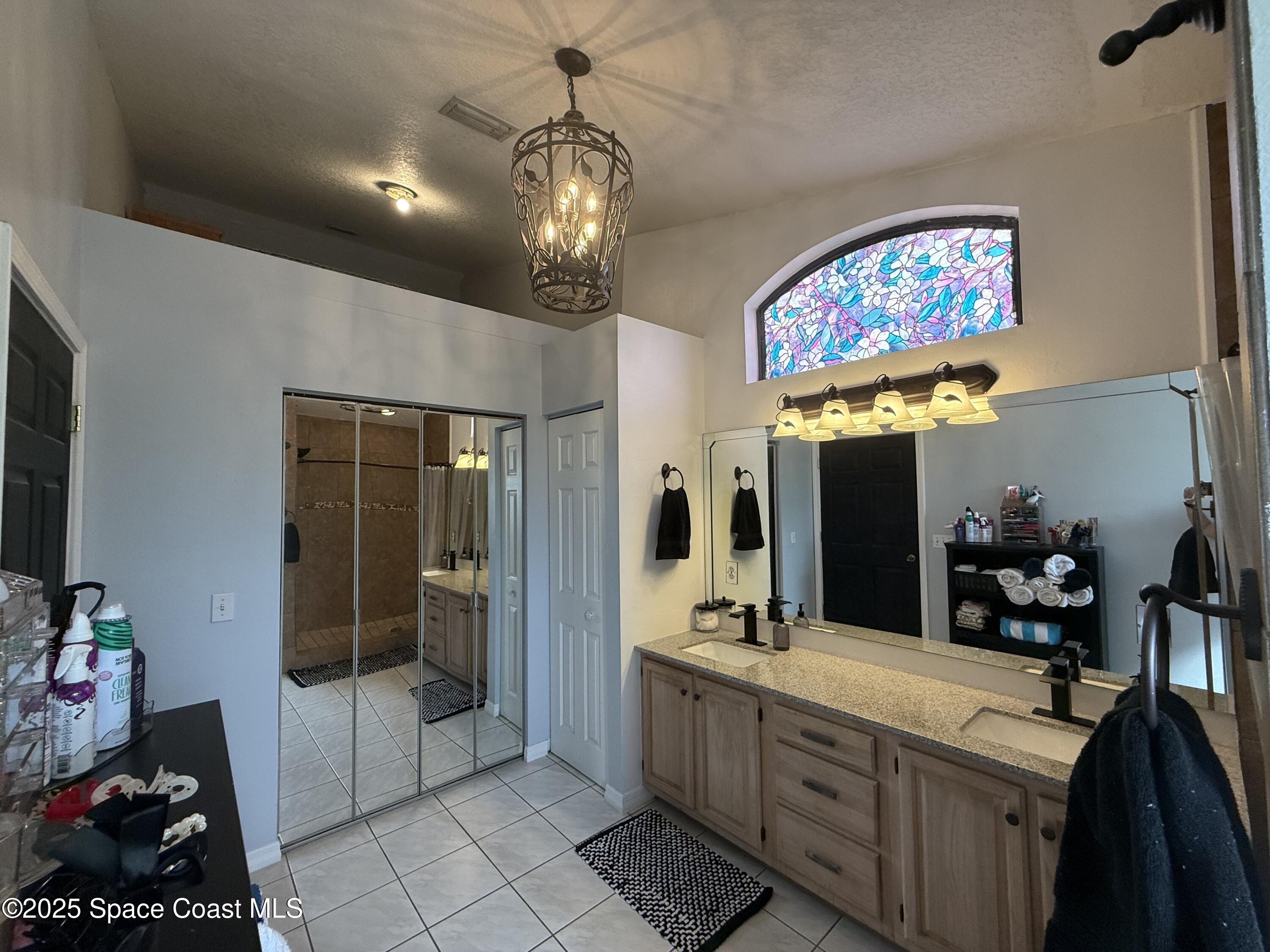 3960 Raney Road Titusville, FL 32780 - Photo 19 of 33 a spacious bathroom with a sink a large mirror and a shower