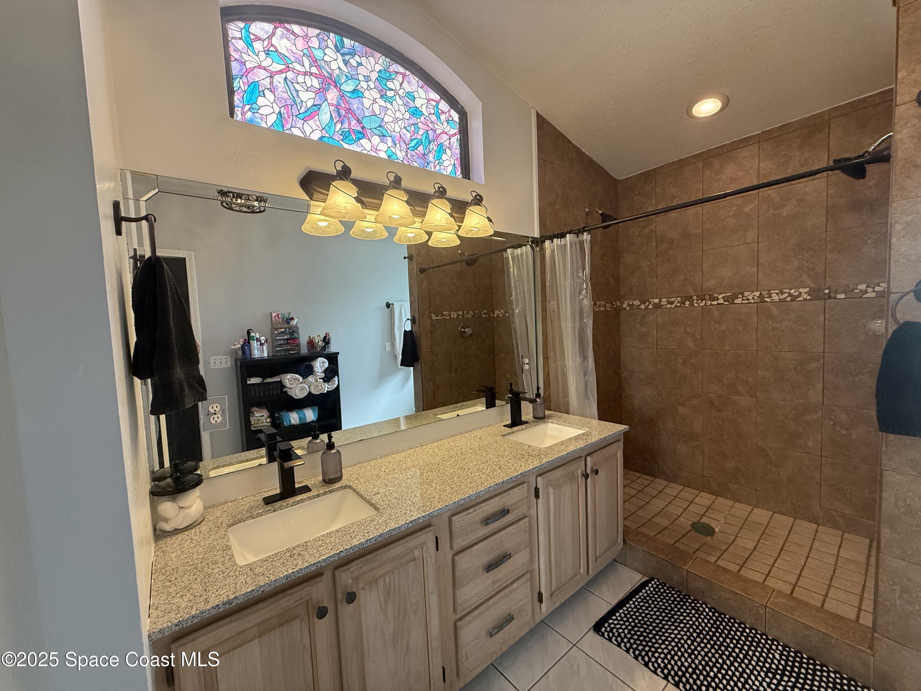 3960 Raney Road Titusville, FL 32780 - Photo 22 of 33 a bathroom with a double vanity sink mirror and shower