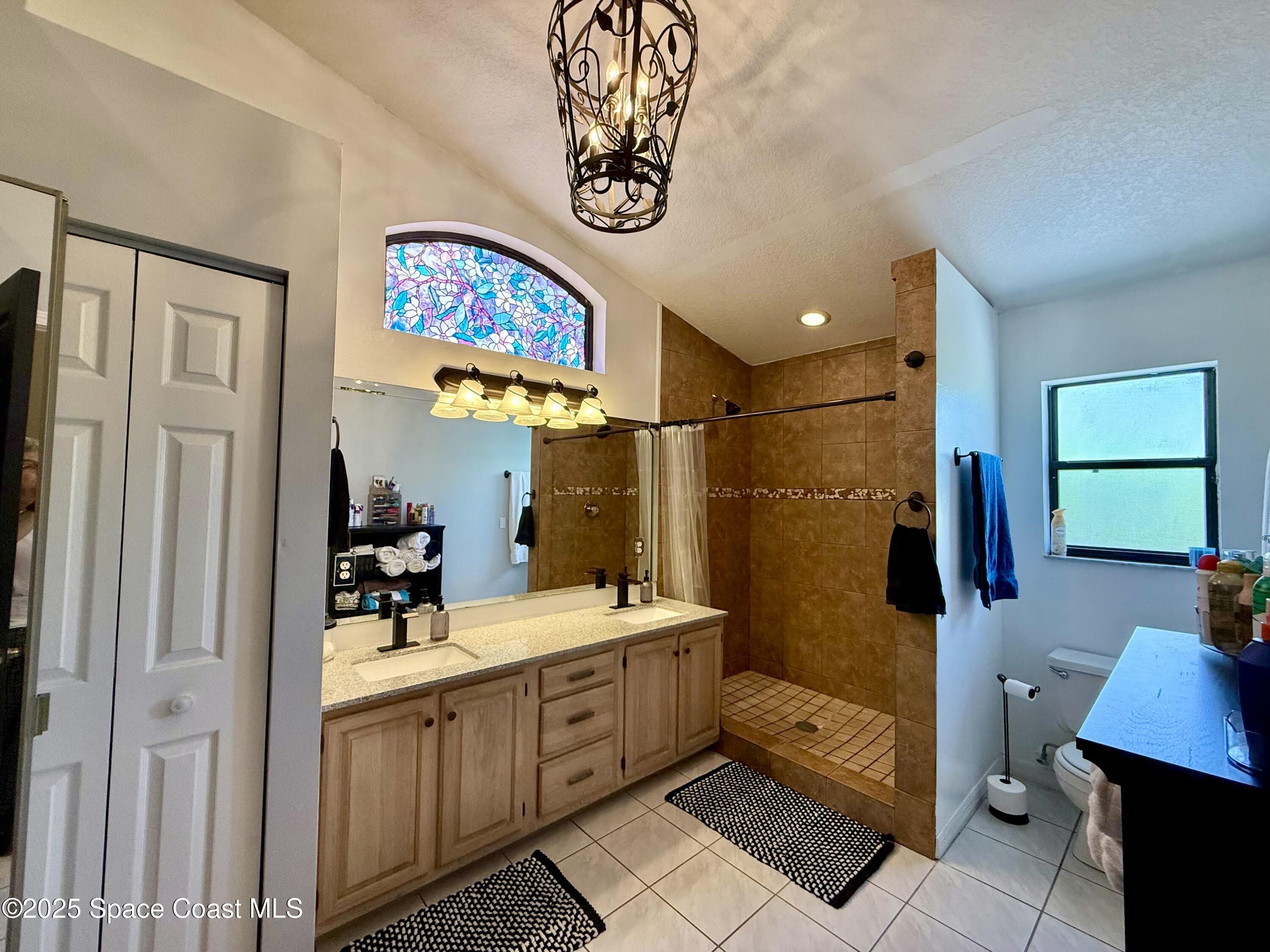 3960 Raney Road Titusville, FL 32780 - Photo 23 of 33 a bathroom with a sink a mirror and a shower