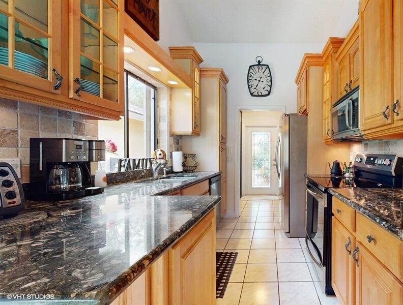 128 Cape Pointe Circle Jupiter, FL 33477 - Photo 11 of 42 a kitchen with stainless steel appliances granite countertop a stove a sink and a refrigerator
