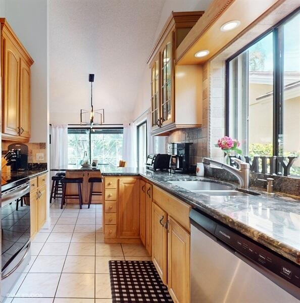 128 Cape Pointe Circle Jupiter, FL 33477 - Photo 12 of 42 a kitchen with stainless steel appliances granite countertop a stove a sink and a microwave