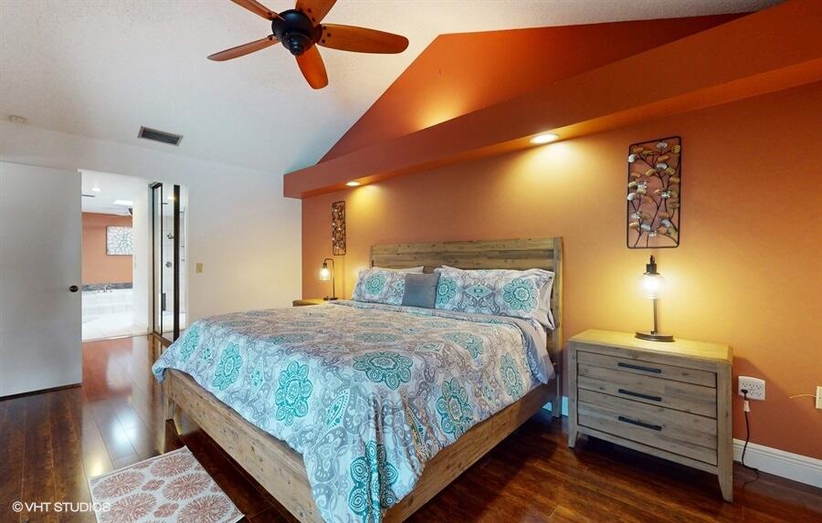 128 Cape Pointe Circle Jupiter, FL 33477 - Photo 19 of 42 a bedroom with a bed and wooden floor